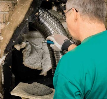 Montere peisinnsats: Det fleksible røret settes på plass Montere peisinnsats: Det fleksible røret settes på plass